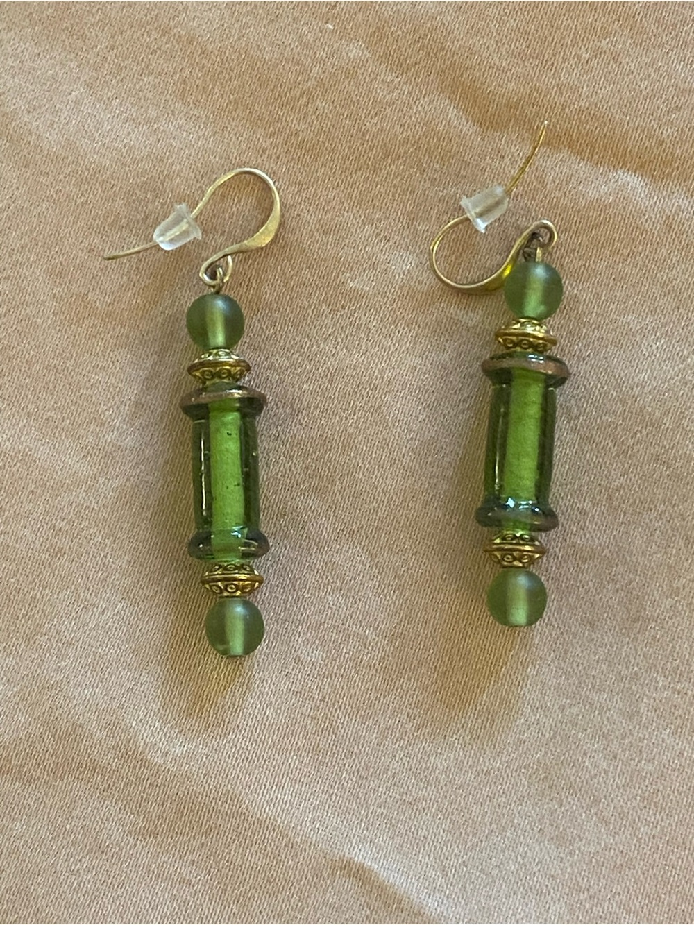 Bold in an under-stated way; dangle earrings in a soft green glass.